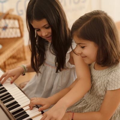 Niñas tocando el piano en música para niños de 6 a 7 años