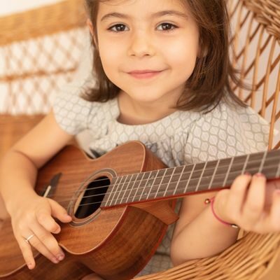 Niña toca el ukelele en música para niños de 6 a 7 años