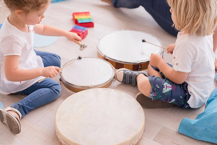 Niños tocando el tambor en clase de música en Granada